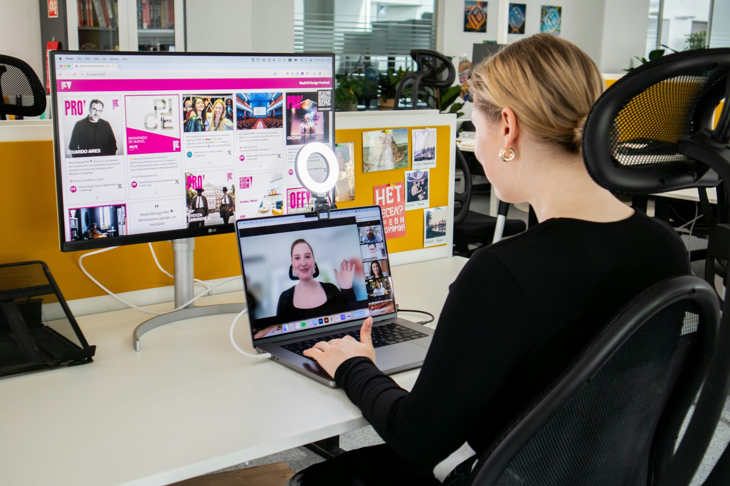 A woman engages in virtual collaboration with her team in a hybrid workspace.